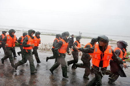 Armed policemen work as rescuers at Hongshan Village in Xiapu County, southeast China's Fujian Province, Aug. 9, 2009. [Jiang Kehong/Xinhua]