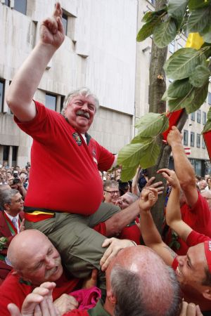 Mayor of Brussels Freddy Thielemans and members of the Meyboom brotherhood celebrate after the planting of the Meyboom tree in central Brussels August 9, 2009. The dates back 701 years and celebrates the 1213 victory of Brussels over the neighbouring city of Leuven in a battle over tax on beer.[Xinhua/Reuters]