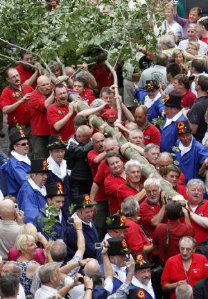 Members of the Meyboom brotherhood carry the Meyboom tree before the planting in central Brussels August 9, 2009.[Xinhua/Reuters]