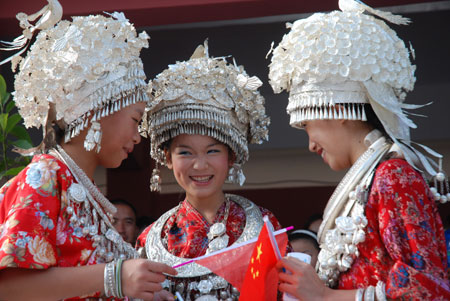 Miao girls in traditional costume smile at the opening ceremony of Julan Cultural Festival in Huangping, a county of southwest China's Guizhou Province, Aug. 8, 2009. [Chen Peiliang/Xinhua]