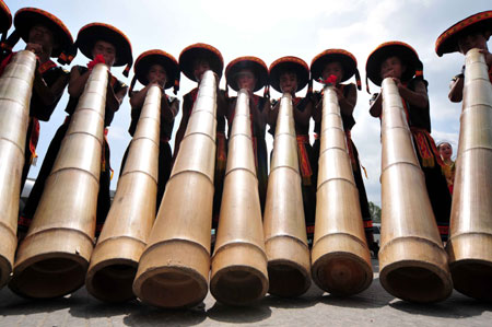 Miao men play mangtong at the opening ceremony of Julan Cultural Festival in Huangping, a county of southwest China's Guizhou Province, Aug. 8, 2009. [Chen Peiliang/Xinhua]