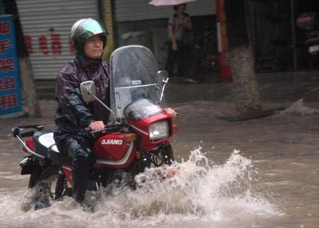 A man rides motorbike on a flooded street in Wenling, east China's Zhejiang Province, Aug. 9, 2009. Typhoon 'Morakot' slammed into Chinese provinces on the eastern coast on Sunday, causing casualties, destroying houses and inundating farmlands. [Xinhua]
