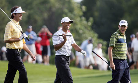 Bubba Watson (L), Tiger Woods (C) and Nick Watney, all of the U.S., share a laugh as they walk on the 11th fairway during a practice round for the 2009 PGA Championship golf tournament at Hazeltine National Golf Club in Chaska, Minnesota, August 10, 2009.