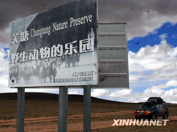 A tourist car runs passing by the road sign of the Changtang National Nature Reserve. [Photo: Xinhuanet]