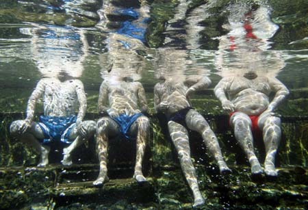 Psoriasis patients relax in a hot spa pool as part of a treatment process, in Kangal 105 kilometers (65 miles) south of the central Anatolian city of Sivas August 9, 2009. The treatment is believed to heal Psoriasis, a chronic skin disease which affects the joints and skins. Garra rufa obtusa, also known as "doctor fish" which live in mineral-rich hot spa pools, is used in the treatment as they nibble away the diseased skin. The mineral-rich water is then believed to aid in the healing process of the lesions. People suffering from psoriasis travel to Kangal to stay at the spa for 21 days and visit the fish pools twice daily for four-hour treatment sessions. 