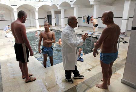 Psoriasis patients talk to a doctor as they stand next to a hot spa pool as part of their treatment process in Kangal, 105 kilometers (65 miles) south of the central Anatolian city of Sivas August 8, 2009.