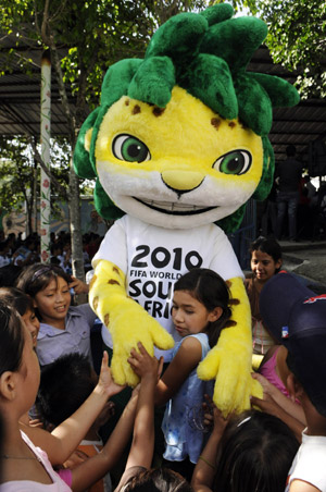 Children hug Zakumi, the official mascot of the 2010 FIFA World Cup South Africa, during a visit to participants of the Football Forever program in the city of Soyapango, 12 km (7 miles) east of San Salvador, August 10, 2009. 