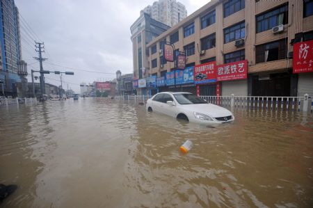 A car is immerged in flood in Cangnan, east China's Zhejiang Province, Aug. 10, 2009. [Wang Dingchang/Xinhua]