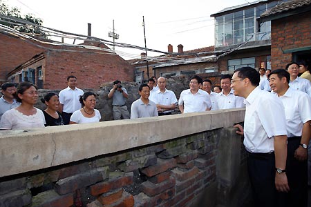 Chinese Vice Premier Li Keqiang (R Front) talks with hut dwellers in the Nanshi hut zone of Shuangyashan, a city in northeast China's Heilongjiang Province. 