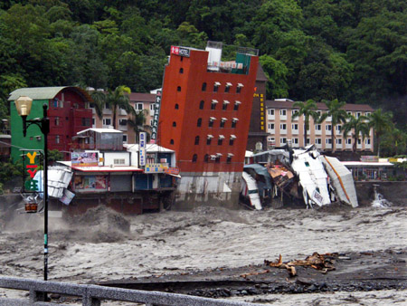 A six-storey hotel building leans before falling into a flooded river after Typhoon Morakot hit Taitung county, eastern Taiwan, August 9, 2009. [Xinhua]