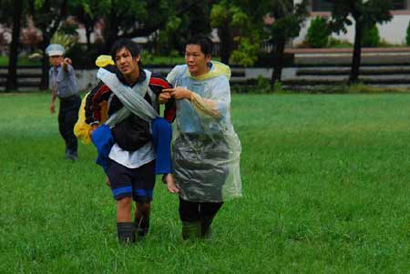Rescuers carry residents to a medical station in Kaohsiung county of south China's Taiwan Province, Aug. 11, 2009. Helicopters rescued many residents trapped by flood and mudslide caused by Typhoon Morakot on Tuesday morning as the weather became clear. At least 62 people were killed and 57 others are missing in Taiwan as of 8 p.m. Tuesday local time after Morakot, the worst typhoon hit the region in nearly five decades, swept across the island.  (Xinhua/Chen Jianxing)