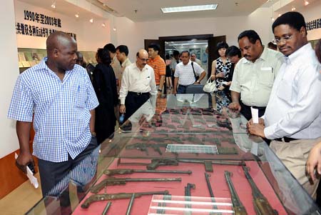 Diplomats watch weapons seized from terrorist cells while visiting an exhibition on the achievements of anti-terrorism and anti-separatism in Xinjiang at Xinjiang Public Security Department in Urumqi, capital of northwest China's Xinjiang Uygur Autonomous Region, Aug. 11, 2009. Diplomats from 26 countries and regions to China visited the exhibition on Tuesday. (Xinhua/