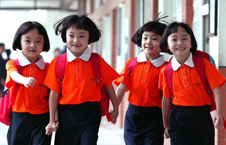 The quadruplet sisters Zhu Wanbing, Zhu Wanqing, Zhu Wanyu and Zhu Wanjie are seen in this file picture taken on August 30, 2005, walking hands in hands for their first day in primary school in Nanjing, east China's Jiangsu province. The quardruplet sisters were naturally conceived and born on August 11, 1999 in Nanjing. (Xinhua/Yao Qiang) 