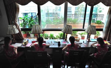 The quadruplet sisters Zhu Wanbing, Zhu Wanqing, Zhu Wanyu and Zhu Wanjie, who are going to be the fifth grade pupils next September, do their homeworks at home in Nanjing, east China's Jiangsu Province, Aug. 6, 2009. The quardruplet sisters were naturally conceived and born in August 11, 1999 in Nanjing. (Xinhua/Yao Qiang) 