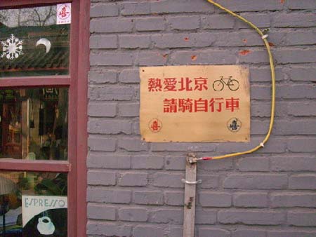 The Chinese characters on the board read 'to love Beijing, please ride a bicycle.'(Photo Source:Chinadaily.com)