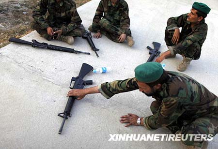 Afghan soldiers rest after firing M-16 rifles during a training session by U.S. forces in Honaker Miracle camp at the Pesh Valley, Kunar Province August 10, 2009. The Afghan National Army has started the process of changing weapons from the old AK-47 to the American M-16 rifle.