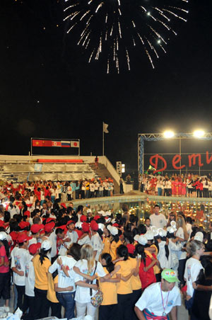 Chinese children and their Russian counsellors watch fireworks together during a soiree at the 