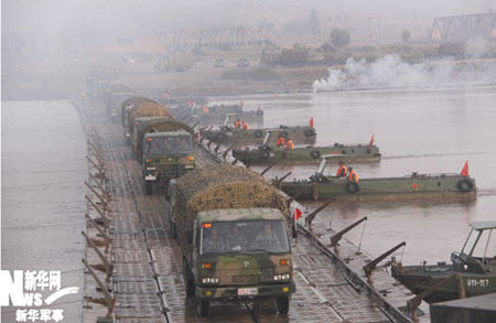 Motorized troops from the military commands of Lanzhou passes a bridge on Tuesday. The exercise 'Stride-2009' participated by one army division from each of the military commands of Shenyang, Lanzhou, Jinan and Guangzhou begins. (Xinhua Photo)