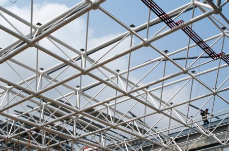 The steel roof of the gymnasium of Tianjin High Middle School in Lueyang, northwest China's Shaanxi province, is assembled Aug. 12, 2009.(Xinhua/Wang Wei)