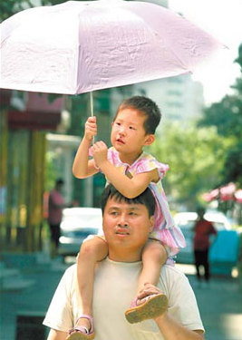 A boy shields himself from the searing heat that reached 37 C yesterday in Beijing as the city's weather bureau issued an orange alert to warn residents of the hot weather. A lack of rainfall has placed tremendous pressure on the city's water supply.  [Wang Jing/China Daily]