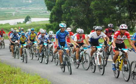 Cyclists compete on the cycling road race in Fangchenggang City of southwest China's Guangxi Zhuang Autonomous Region, Aug. 12, 2009.(Xinhua/Liang Fuying) 