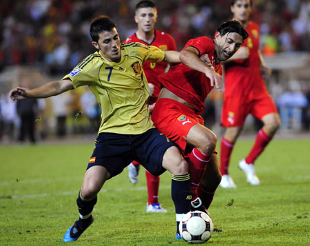 David Villa of Spain (L) battles for the ball with Igor Mitrevski of Macedonia during their international friendly soccer match in Skopje August 12, 2009.