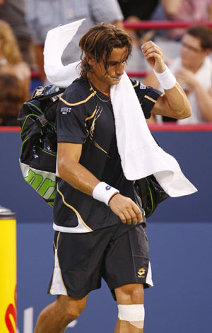 David Ferrer of Spain walks off the court after retiring during the first set of his match against compatriot Rafael Nadal at the Rogers Cup tennis tournament in Montreal August 12, 2009