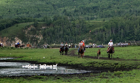 Tourists visit the obo, which is a heap of sand, stone or earth laid out as a road marker or boundary and is also worshipped as habitation of spirits by Mongolians, in Hulun Buir grassland, north China's Inner Mongolia Autonomous Region, on Aug. 10, 2009.