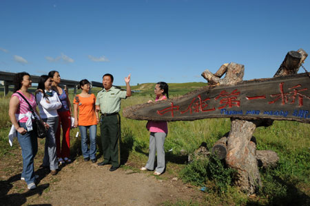 Tourists visit the obo, which is a heap of sand, stone or earth laid out as a road marker or boundary and is also worshipped as habitation of spirits by Mongolians, in Hulun Buir grassland, north China's Inner Mongolia Autonomous Region, on Aug. 10, 2009.