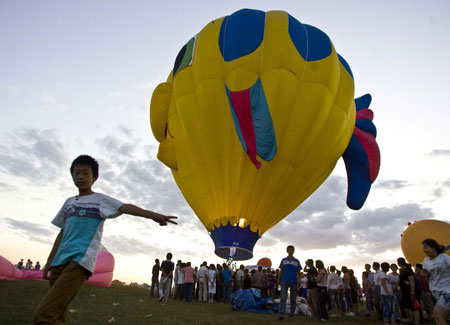 People enjoy watching a rising hot-air balloon in Guyang County of Baotou City, north China's Inner Mongolia Autonomous Region, on Aug. 12, 2009. 