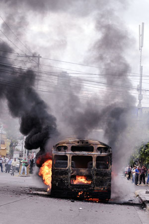 Smoke rises from a burning bus after supporters of ousted Honduran President Manuel Zelaya set it on fire in Tegucigalpa, capital of Honduras, Aug. 11, 2009.