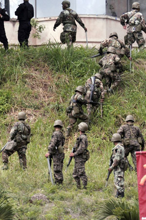 Honduran soldiers climb up a slope during a duty as supporters of ousted Honduran President Manuel Zelaya held a protest in Tegucigalpa, capital of Honduras, Aug. 11, 2009