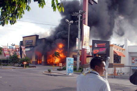 Smoke rises from a burning restaurant after supporters of ousted Honduran President Manuel Zelaya set it on fire in Tegucigalpa, capital of Honduras, Aug. 11, 2009.