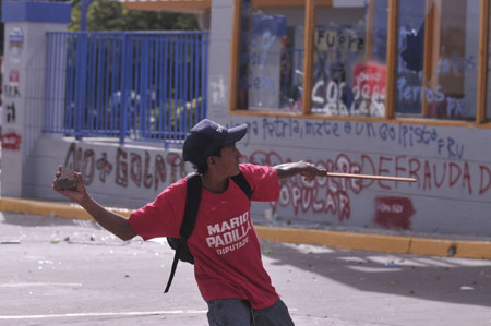 A man throws a stone during a protest held by supporters of ousted Honduran President Manuel Zelaya in Tegucigalpa, capital of Honduras, Aug. 11, 2009. 