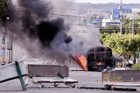 Smoke rises from a burning bus after supporters of ousted Honduran President Manuel Zelaya set it on fire in Tegucigalpa, capital of Honduras, Aug. 11, 2009. 