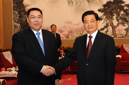 Chinese President Hu Jintao (R) shakes hands with the new chief executive of the Macao Special Administrative Region Chui Sai On, in Beijing, capital of China, Aug. 12, 2009. 