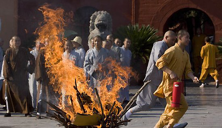 Monks from the white horse temple practice using fire extinguisher after fireproofing officers teach them how to put out a fire, in Luoyang, central China's Henan province, August 13, 2009. 