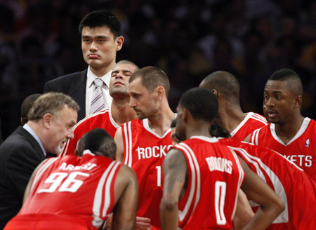 Injured Houston Rockets center Yao Ming stands over his team as coach Rick Adelman talks with Shane Battier, Brent Barry, Ron Artest, Aaron Brooks,and Chuck Hayes as they take a time-out against the Los Angeles Lakers during Game 7 of their NBA Western Conference semi-final basketball playoff game in Los Angeles, May 17, 2009. (Xinhua/Reuters file Photo) 