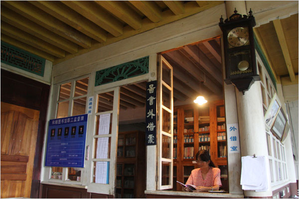 An assistant at the Issue Desk of Heshun Library. [Photo: CRIENGLISH.com /Bao Congying]