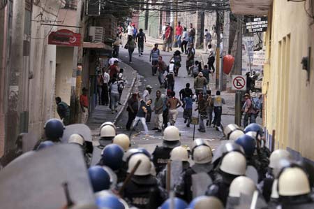 Supporters of ousted Honduran President Manuel Zelaya throw stones to policemen and soldiers during a protest in Tegucigalpa, capital of Honduras, on Aug. 12, 2009. Hundreds of Honduras people were arrested since the protest Sunday for demanding Zelaya's restitution as president of the country. (Xinhua/Rafael Ochoa)