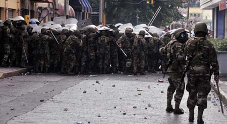 Policemen and soldiers guard on the street during a protest held by supporters of ousted Honduran President Manuel Zelaya in Tegucigalpa, capital of Honduras, on Aug. 12, 2009. Hundreds of Honduras people were arrested since the protest Sunday for demanding Zelaya's restitution as president of the country. (Xinhua/Rafael Ochoa) 