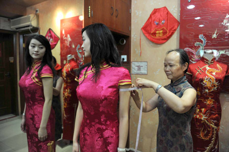 A stewardess from Chinese Sichuan Airlines tries her Chi-pao on at a tailor's in Chengdu, southwest China's Sichuan province, August 12, 2009. Stewardesses of some air routes of Sichuan Airlines will wear Chi-pao as their uniforms. The Chi-pao, a traditional Chinese skirt for ladies, is designed slit up to the thigh on each side. (Xinhua) 