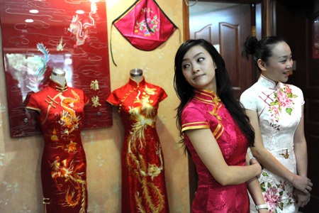 Two stewardesses from Chinese Sichuan Airlines try their Chi-pao on at a tailor's in Chengdu, southwest China's Sichuan province, August 12, 2009. Stewardesses of some air routes of Sichuan Airlines will wear Chi-pao as their uniforms. The Chi-pao, a traditional Chinese skirt for ladies, is designed slit up to the thigh on each side. (Xinhua) 