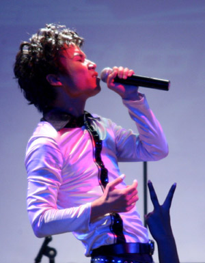 A singer sings a song by the deceased American singer Michael Jackson at a charity concert held in the Star Live in Beijing, capital of China, August 12, 2009. All the revenue of the concert held here Wednesday night would be donated to the working committee for rescuing children under the China Association for Social Workers to aid orphans in China.
