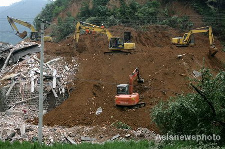 Excavators are seen digging through the rubble of a landslide in Lin'an city, East China's Zhejiang province, August 14, 2009. The landslide, believed to be triggered by a heavy downpour, left 11 dead and 2 injured. 