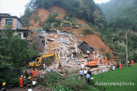 Firefighters, policemen and excavators are seen at the scene of a landslide rescue operation in Lin'an city, East China's Zhejiang province, August 14, 2009. The landslide, believed to be triggered by a heavy downpour, left 11 dead and 2 injured. [Asiannewsphoto.com] 