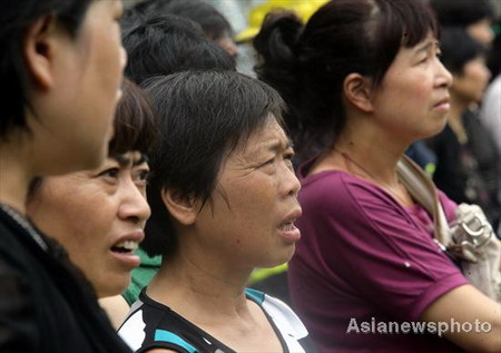 Local residents wait anxiously at the scene of a landslide as rescue operation carries on in Lin'an city, East China's Zhejiang province, August 14, 2009. The landslide, believed to be triggered by a heavy downpour, left 11 dead and 2 injured. [Asiannewsphoto.com]