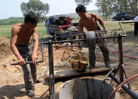Farmers fetch water from a well dug by themselves in Fuxin Mongolia Autonomous County, Fuxin city, northeast China's Liaoning Province, Aug. 14, 2009.(