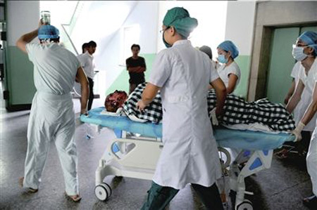 A seriously-injured worker is carried to an intensive care unit by medical staff in Beijing, August 13, 2009. [Xinhua] 