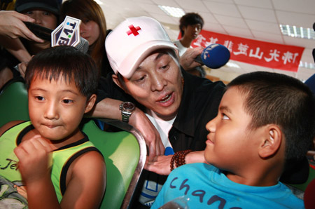 Chinese actor Jet Li (C) sings a song with children at a shelter in Chishan Town of Kaohsiung in southeast China's Taiwan, Aug. 15, 2009.(Xinhua Photo)